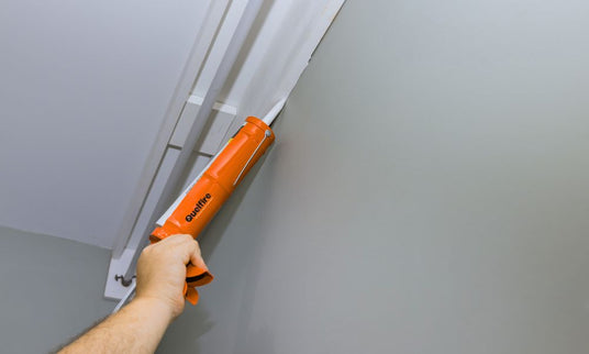 An orange Quelfire sealant gun in use.