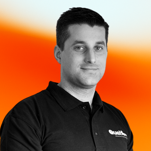 Image of Adrian Wells, R&D Director, with a black-and-white filter. The background is an orange and white gradient.